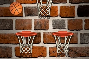 Tre basketballkurve og en basketball på en murstensvæg