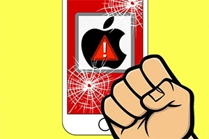 En knytnæve foran en smartphone-skærm med et knust glas og et advarselssymbol over et æblelogo