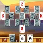 Kortspil-layout med spillekort arrangeret foran en ørkenbaggrund og egyptiske statuer