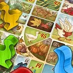 Farvestrålende spillebrikker formet som dyr på en dekoreret spilleplade med numre og illustrationer