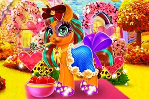 Farverig pony med en stor sløjfe og en blå kjole står foran et blomsterdækket hus med et hjertebuket og en skål med æbler