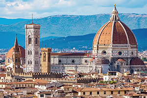 Panorama over Firenze med domkirken Santa Maria del Fiore, den store røde kuppel og Giottos klokketårn foran bjergene i baggrunden