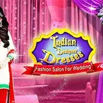 En kvinde i en traditionel indisk kjole står foran en lyserød baggrund med et skilt, der viser teksten Indian Designer Dresses og Fashion Salon For Wedding