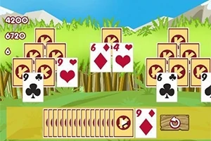 Kortspil-layout med stablede kort mod en baggrund af græs og bjerge
