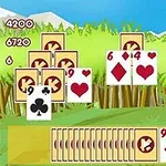 Kortspil-layout med stablede kort mod en baggrund af græs og bjerge