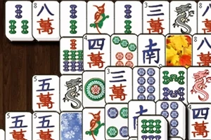 Et udsnit af mahjong-brikker med forskellige symboler og farver arrangeret på en træbaggrund