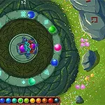 Farverig spiral med kugler arrangeret omkring et centralt mønster på en grøn, blomstret baggrund med sten