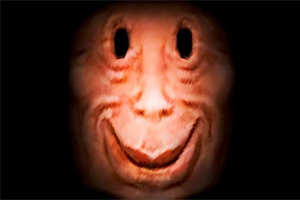 Et surrealistisk og forvrænget ansigt med et stort smil og mørke, hulagtige øjne mod en sort baggrund