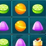 Farverigt gitter med forskellige slik og desserter, herunder lime skiver, orange bolcher, lilla pyramide-slik og kager med topping