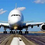 Et stort passagerfly set forfra, der står på en startbane under en klar blå himmel