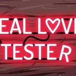 Neonlysende ord REAL LOVE TESTER på en træbaggrund med hjertemotiv integreret i teksten
