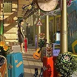 En togstation med en blå og gul togvogn, kufferter, blomster, en guitar og en stor ur i midten