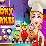 Tegning af en smilende kvinde iført kokkehue, der holder et fad med halloween-cupcakes med forskellige ansigter, ved siden af teksten Spooky Cupcakes