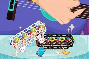 Hånd spiller guitar med farverige armbånd og vedhæng som kanin og måne
