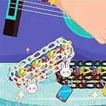 Hånd spiller guitar med farverige armbånd og vedhæng som kanin og måne